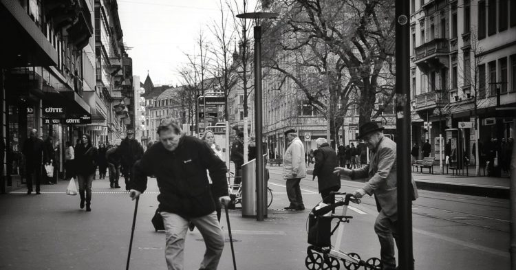 homme marche dans la rue avec des bequilles