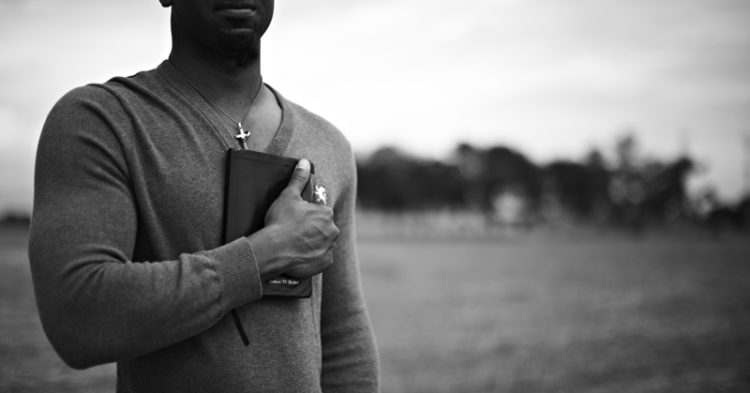 chretien noir avec une bible sur le poitrine