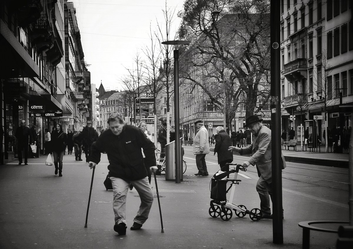 homme marche dans la rue avec des bequilles