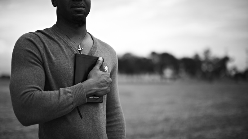 chretien noir avec une bible sur le poitrine